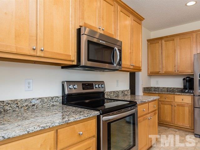 1232 Jogging Court Raleigh, NC 27603 - Photo 8 of 25 a kitchen with granite countertop a stove top oven microwave and cabinets