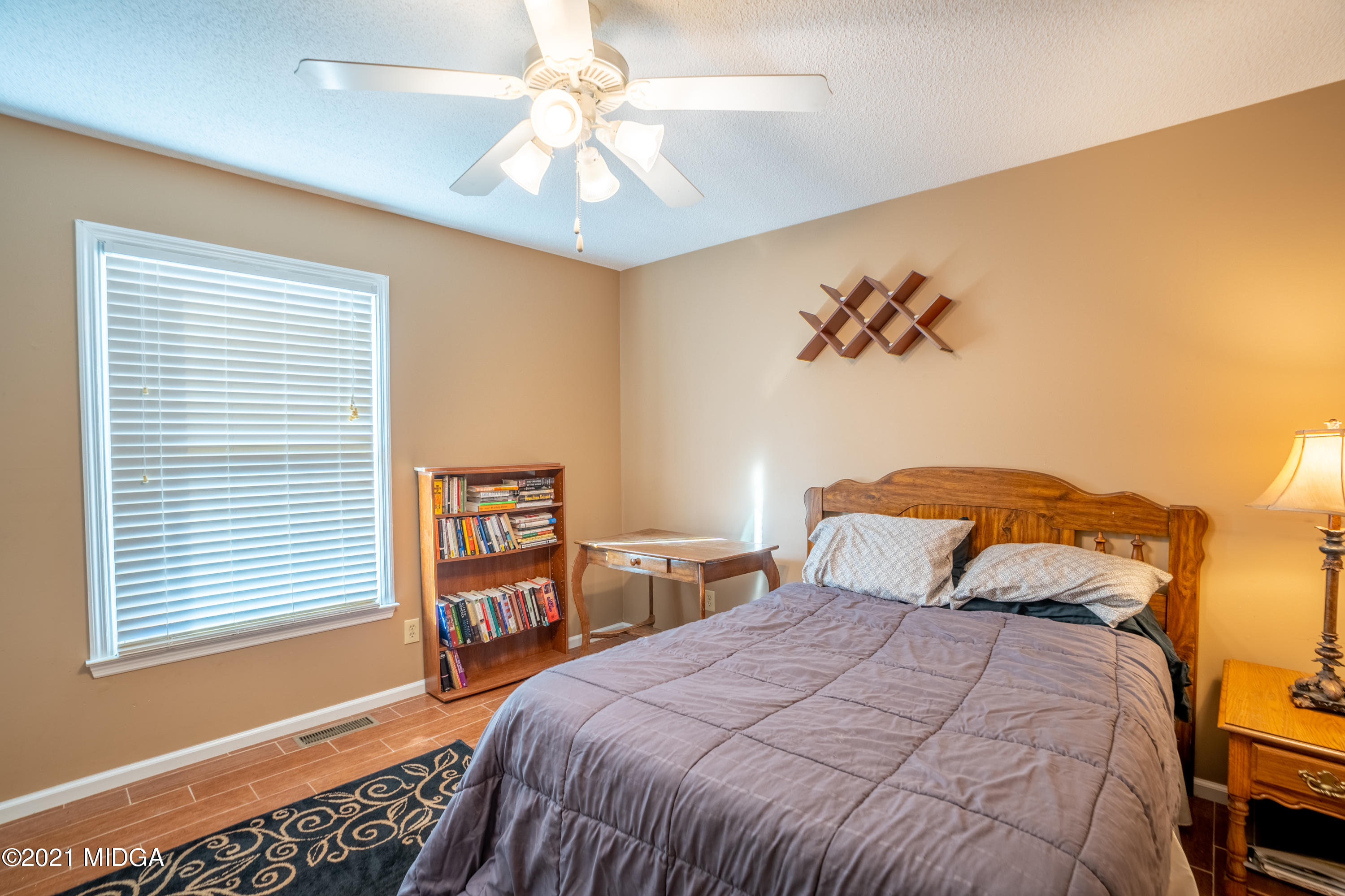 208 Camelot Road Gray, GA 31032 - Photo 24 of 41 a bedroom with a bed and a chandelier