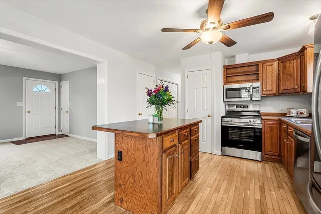 a kitchen with stainless steel appliances kitchen island granite countertop a stove a sink dishwasher and a refrigerator