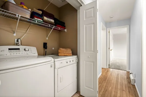 a view of washer and dryer with wooden floor
