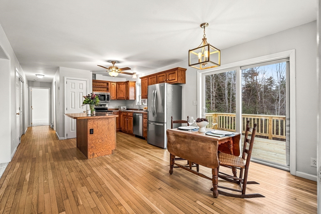 454 Little Pond Road Sandwich, NH 03227 - Photo 7 of 38 a dining room with furniture a chandelier and wooden floor