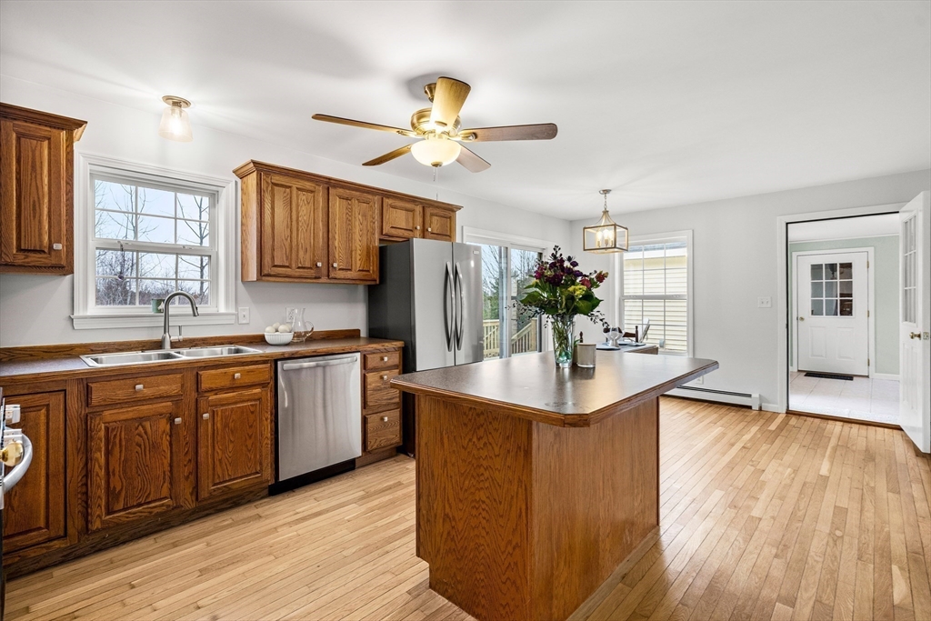 454 Little Pond Road Sandwich, NH 03227 - Photo 8 of 38 a kitchen with stainless steel appliances granite countertop a sink cabinets and wooden floor