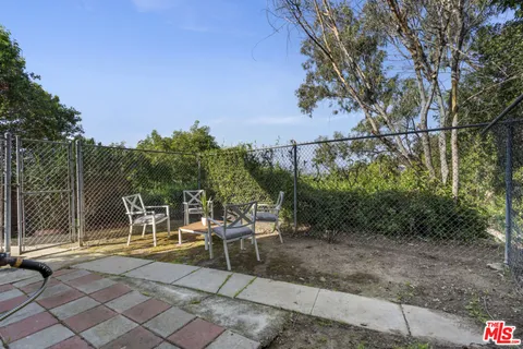 a view of a chairs and table in backyard