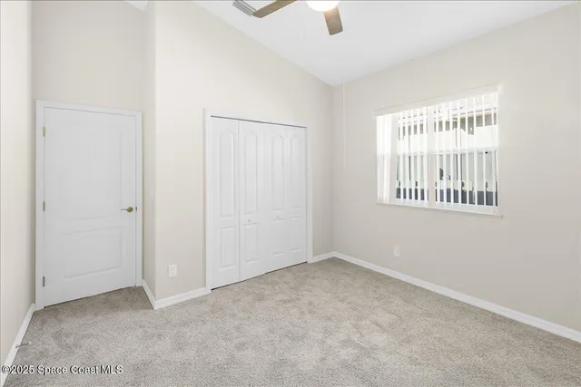 an empty room with a window and a fan