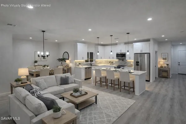 a living room with lots of furniture and kitchen view