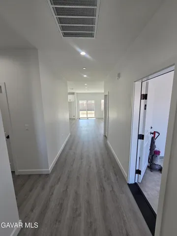 a view of a big room with wooden floor and windows