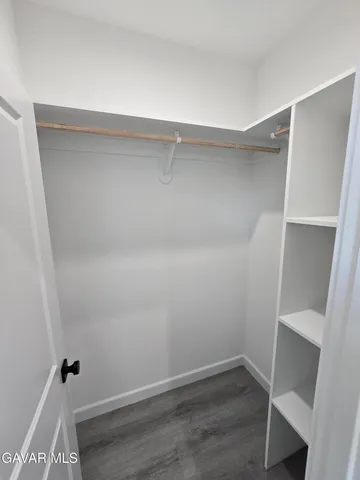 a view of walk in closet with empty racks
