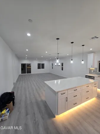 a view of an empty room with wooden floor and windows