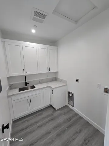 a kitchen with a sink cabinets and wooden floor