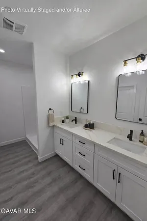 a large kitchen with stainless steel appliances a large counter top a stove a sink dishwasher and a refrigerator