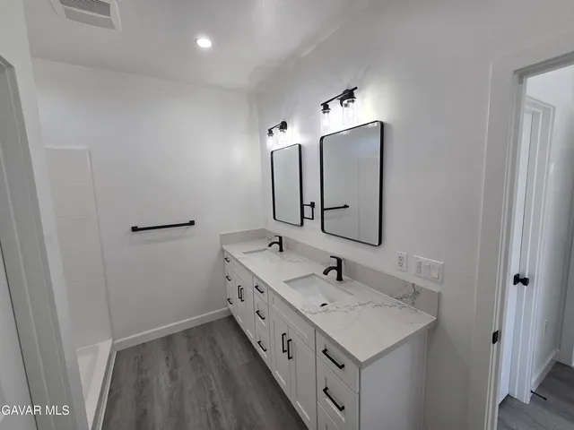 a bathroom with a double vanity sink and mirror