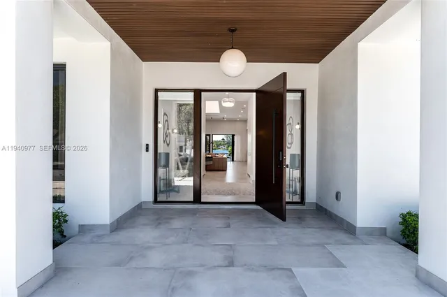 a living room with furniture kitchen view and a large window