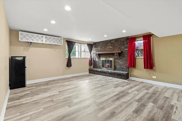a view of an empty room with a fireplace and a window