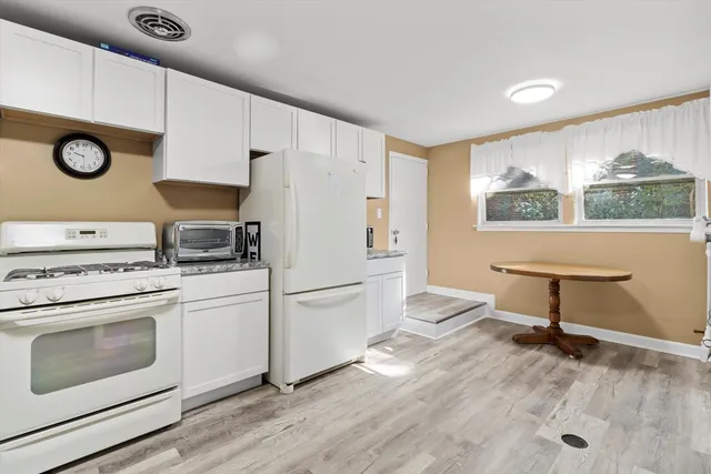 a kitchen with a refrigerator and a stove top oven