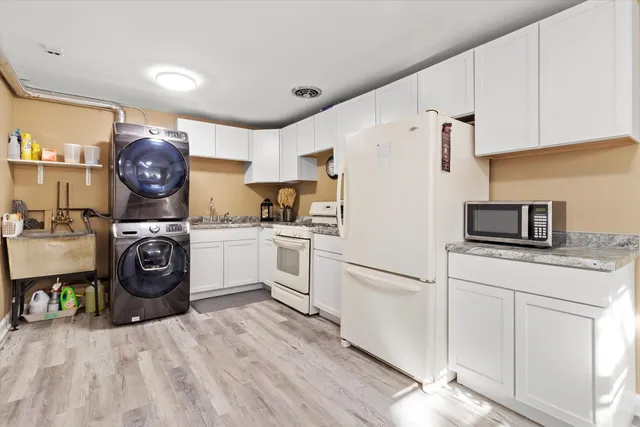 a kitchen with white cabinets and white appliances