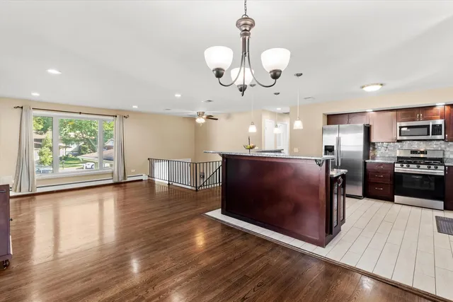 an open kitchen with wooden floor and large cabinets