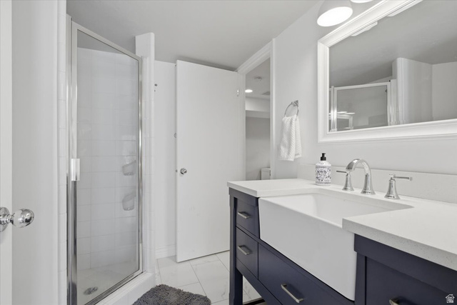12317 Cypress Point Way Draper, UT 84020 - Photo 29 of 41 Modern bathroom featuring a farmhouse-style sink with a two-handle faucet, set into a dark blue vanity with a light-colored countertop