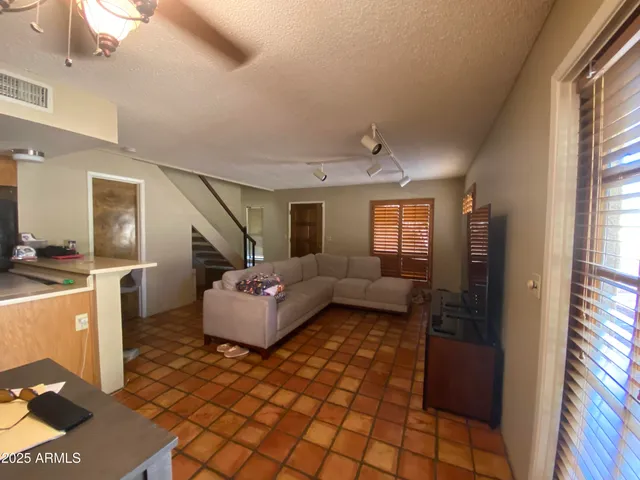 a view of a hallway with wooden floor and a bathroom