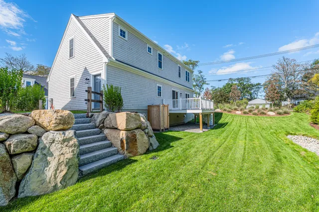 a view of a house with backyard and sitting area