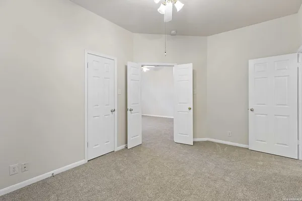 an empty room with chandelier fan