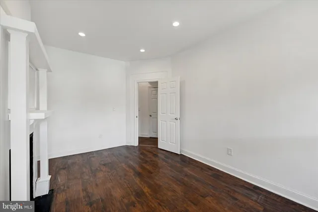an empty room with wooden floor and entrance