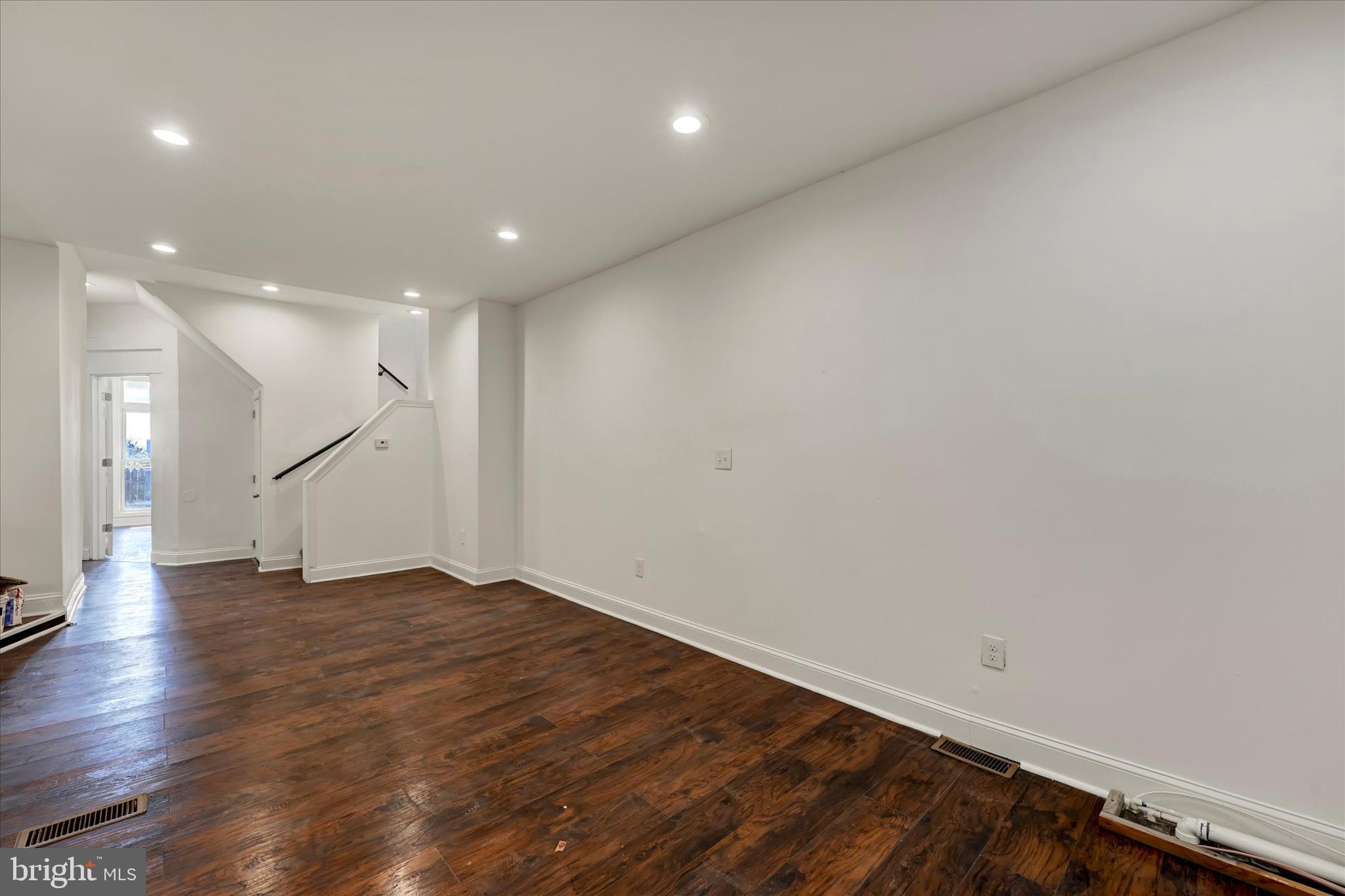 346 East 25th Street Baltimore, MD 21218 - Photo 14 of 31 a view of empty room with wooden floor and stairs