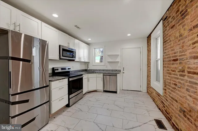 a kitchen with stainless steel appliances a refrigerator sink and microwave