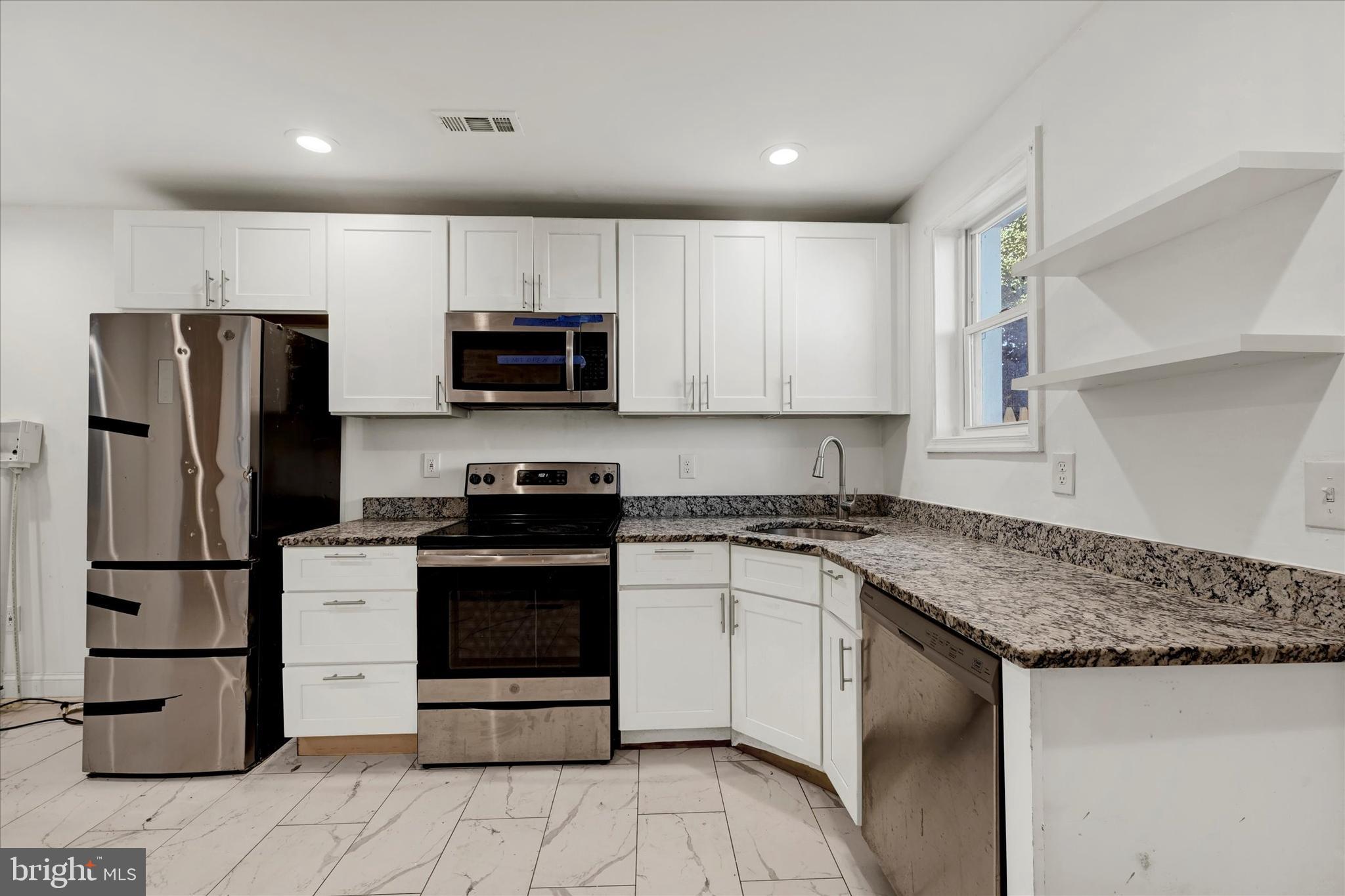 346 East 25th Street Baltimore, MD 21218 - Photo 19 of 31 a kitchen with stainless steel appliances granite countertop a stove a refrigerator and a sink