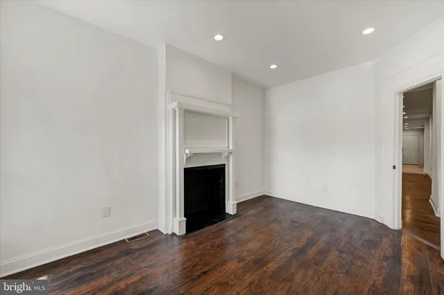 a view of empty room with wooden floor and fireplace
