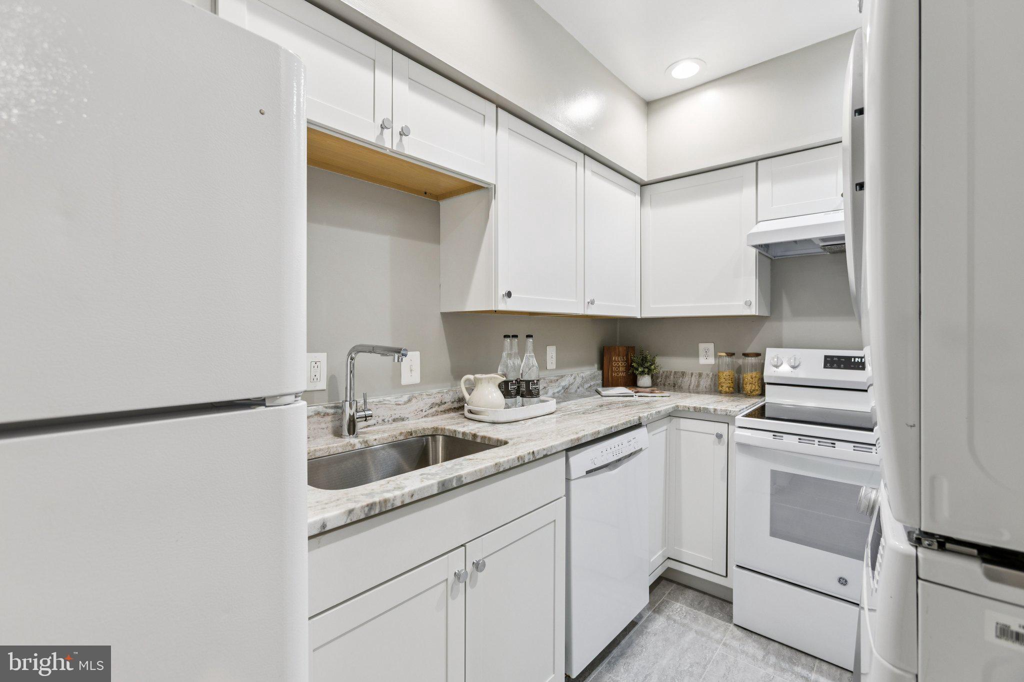 406 15th Street Southeast Washington, DC 20003 - Photo 7 of 39 a kitchen with white cabinets and white appliances