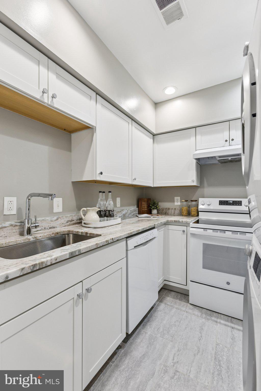 406 15th Street Southeast Washington, DC 20003 - Photo 8 of 39 a kitchen with granite countertop white cabinets and white appliances
