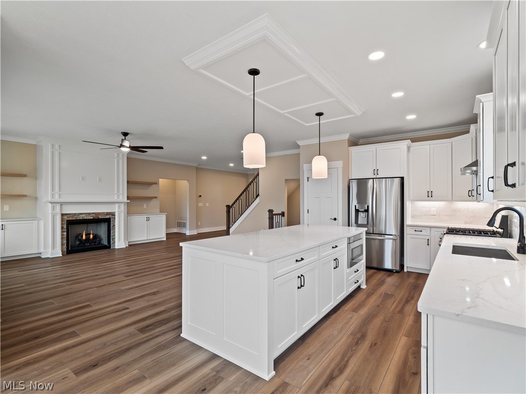 34270 Brookside Lane North Ridgeville, OH 44039 - Photo 20 of 50 Kitchen featuring a center island, white cabinets, light stone counters, stainless steel appliances, and dark wood-style floors