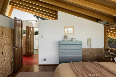 a bedroom with bed and large windows