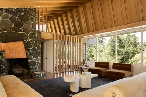 a living room with furniture and floor to ceiling windows