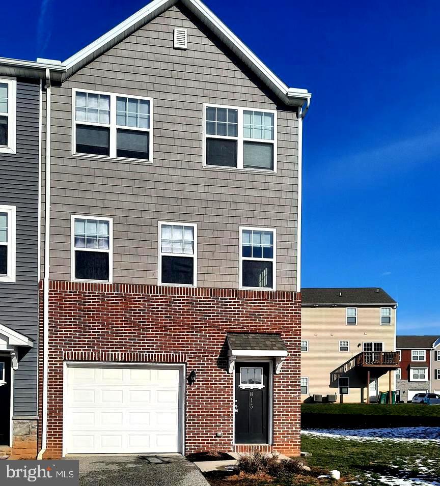 a front view of a house with garage and lawn chairs