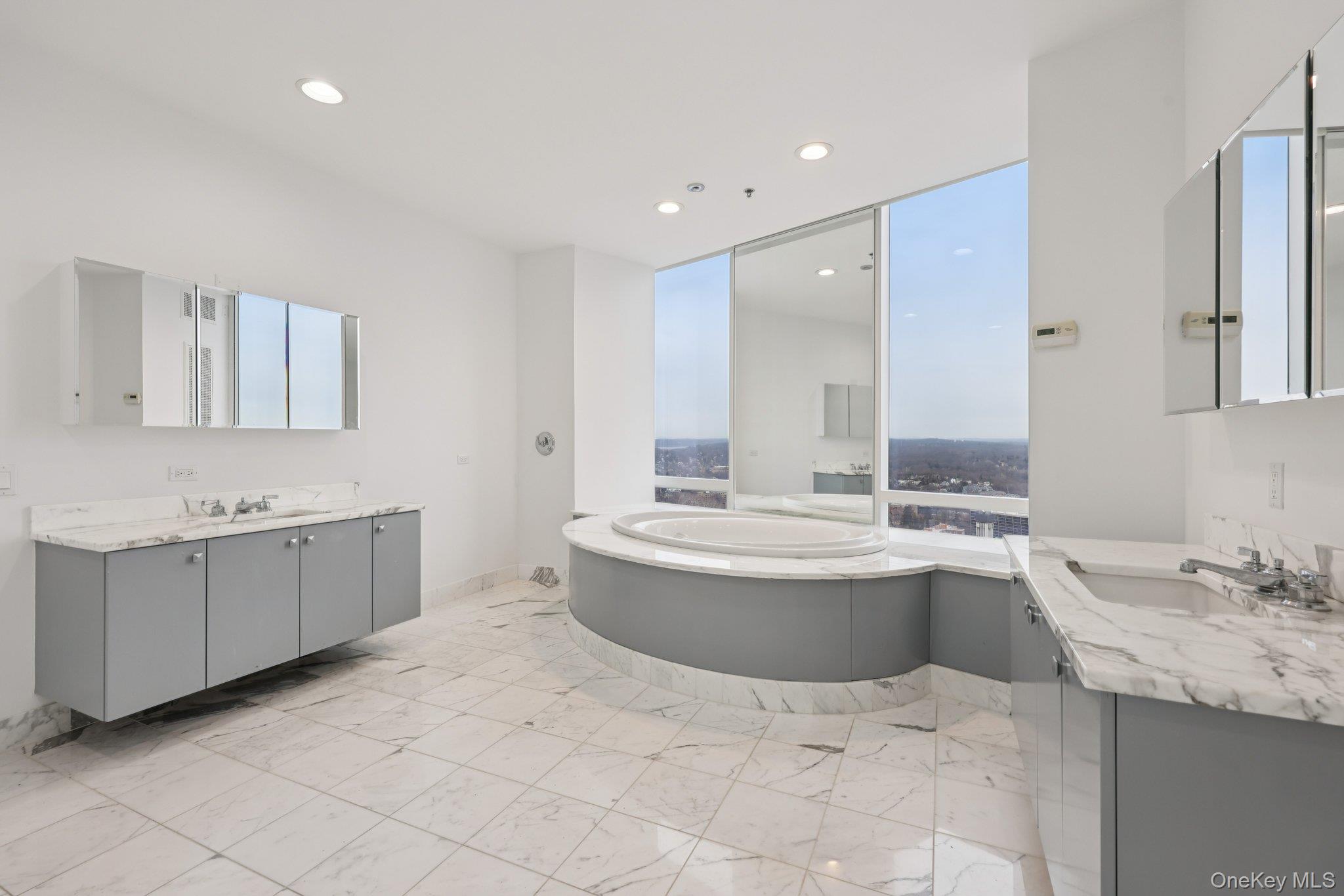 1 Renaissance Square, Unit PH40C White Plains, NY 10601 - Photo 11 of 25 Bathroom featuring two vanities, light marble finish floors, a bath, and recessed lighting
