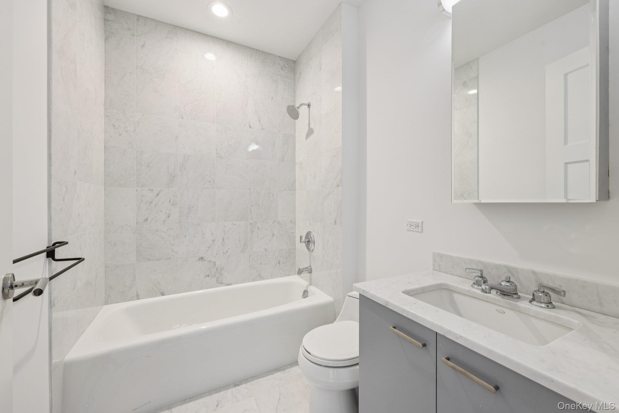 1 Renaissance Square, Unit PH40C White Plains, NY 10601 - Photo 18 of 25 Full bath featuring vanity, shower combination, recessed lighting, and light marble finish floors