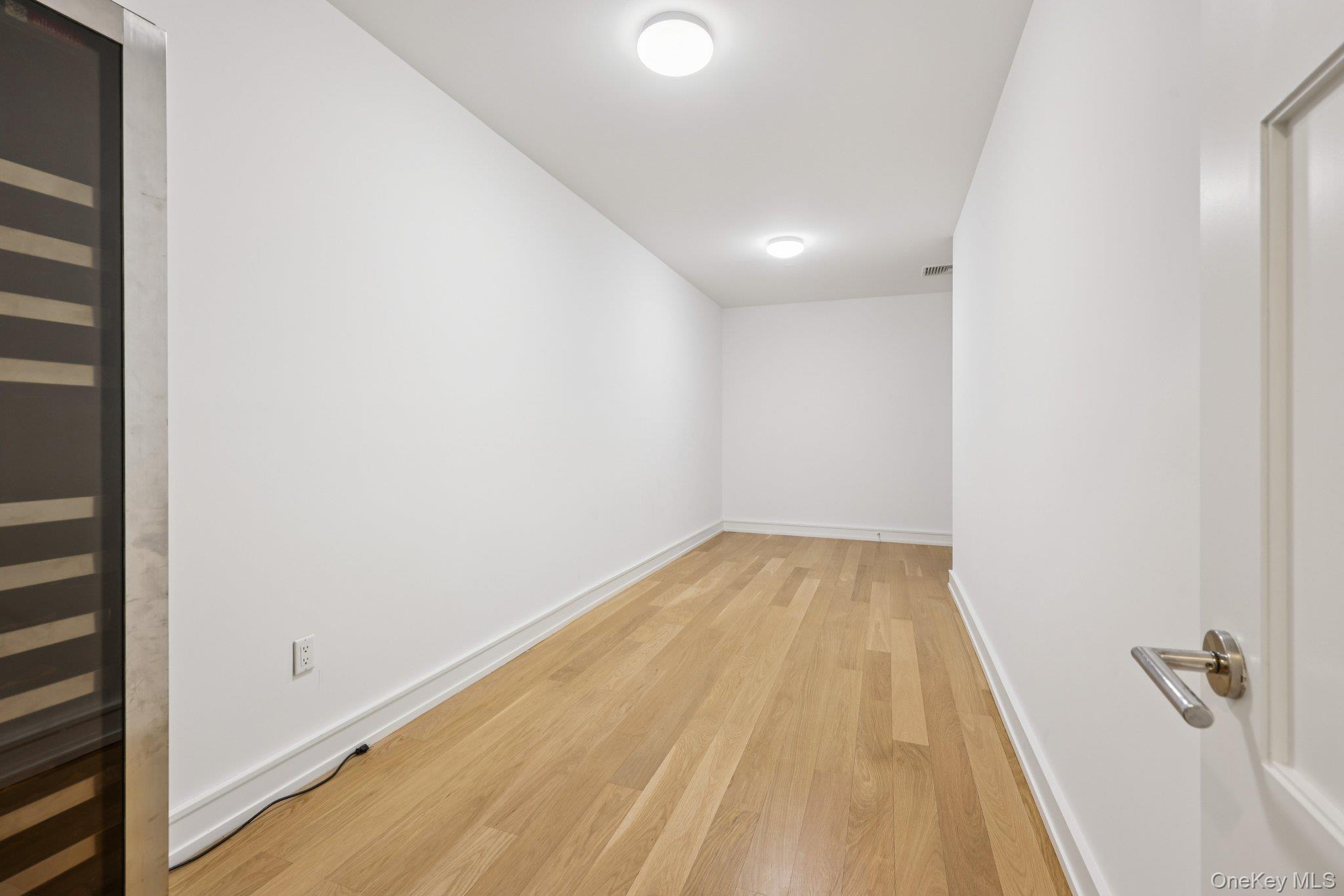 1 Renaissance Square, Unit PH40C White Plains, NY 10601 - Photo 20 of 25 Empty room featuring beverage cooler and light wood finished floors