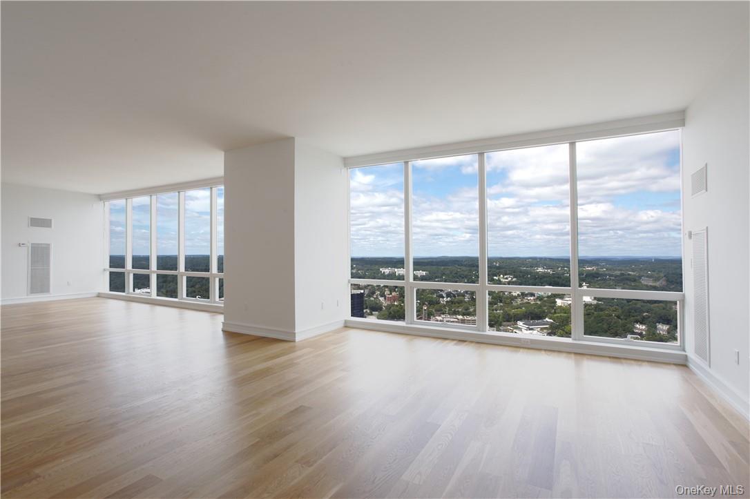 1 Renaissance Square, Unit PH40C White Plains, NY 10601 - Photo 4 of 14 a view of an empty room with wooden floor and a floor to ceiling window