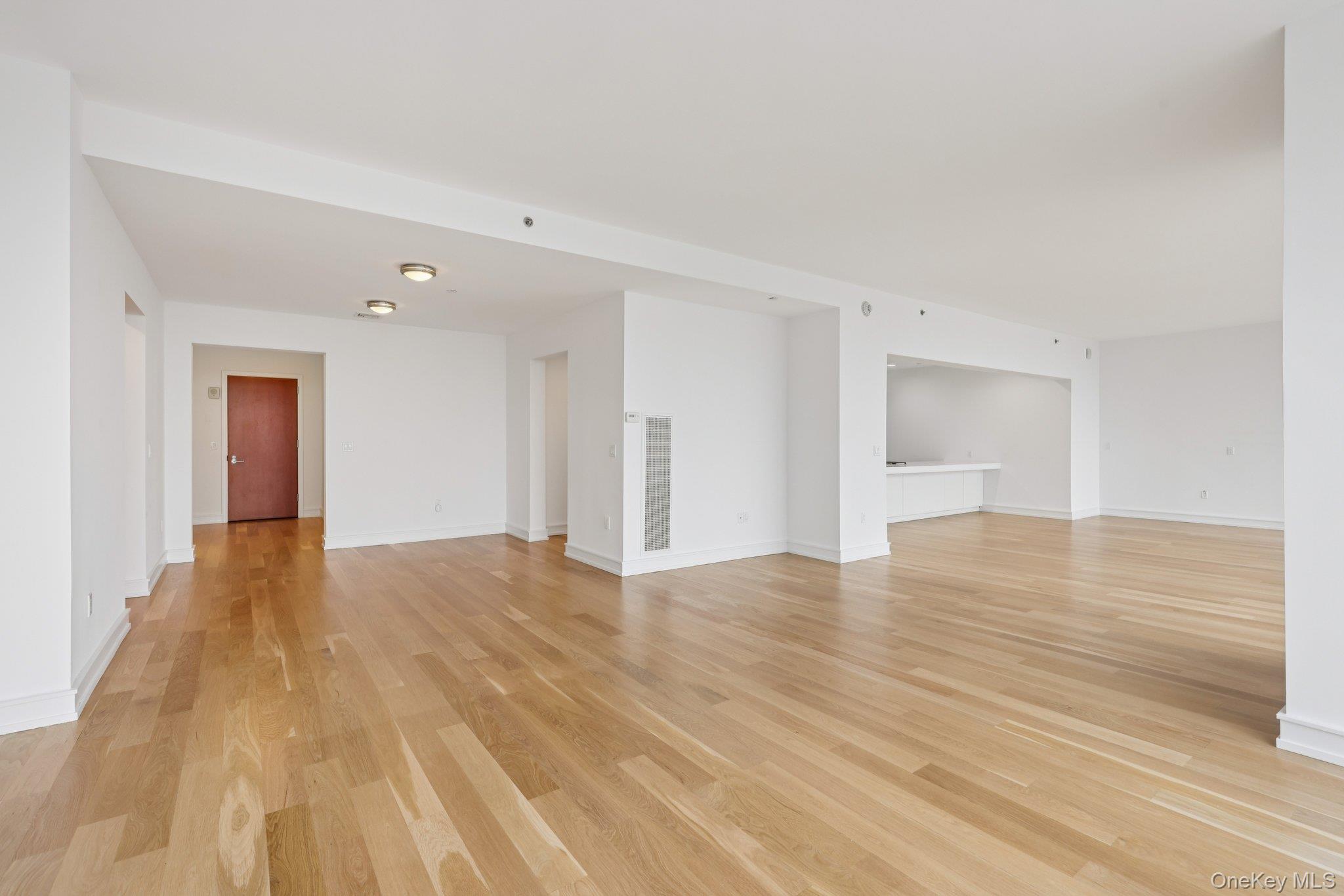 1 Renaissance Square, Unit PH40C White Plains, NY 10601 - Photo 5 of 25 Unfurnished living room with light wood-style floors and baseboards