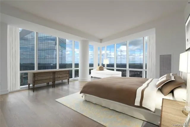 a bedroom with a bed and a large window with outer view