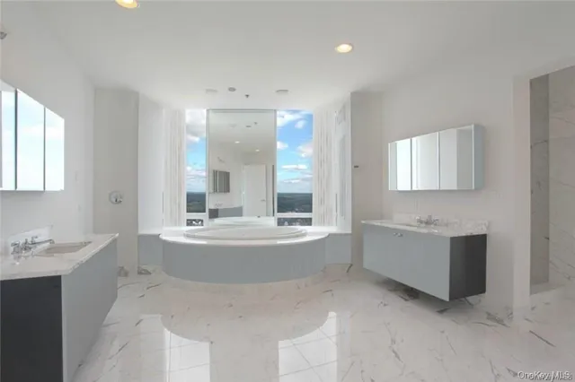 a bathroom with a tub sink and mirror