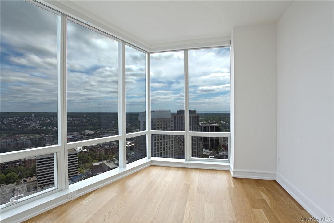 1 Renaissance Square, Unit PH40C White Plains, NY 10601 - Photo 9 of 14 a view of an empty room with wooden floor and a window
