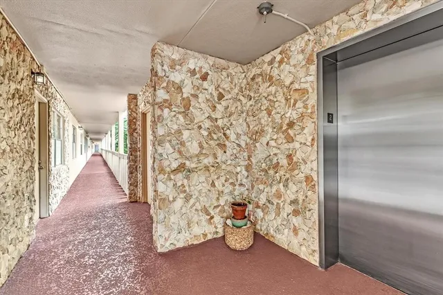 a view of a hallway with wooden floor and entryway
