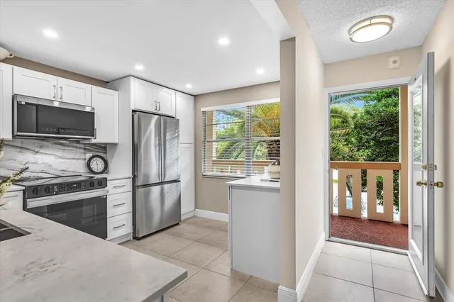 a kitchen with stainless steel appliances granite countertop a refrigerator and a stove top oven