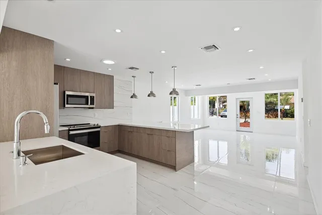 a kitchen with stainless steel appliances granite countertop a refrigerator and a stove top oven