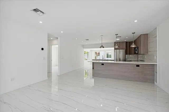 a large kitchen with white cabinets and stainless steel appliances