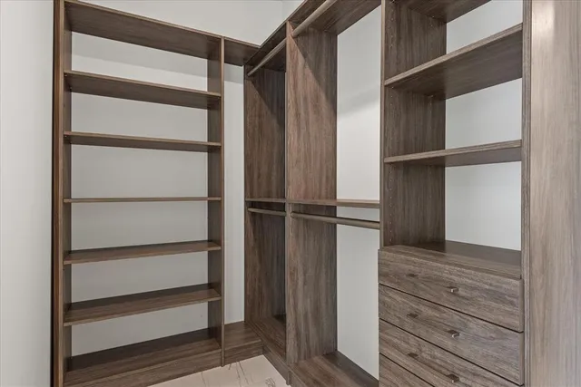 a view of walk in closet with empty racks