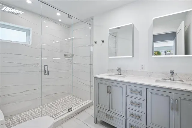 a bathroom with a shower sink and mirror