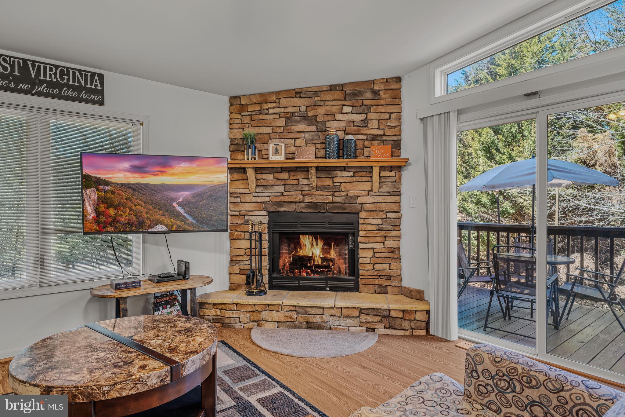 72 Medfords Lane Berkeley Springs, WV 25411 - Photo 12 of 52 a living room with furniture a large window and a fireplace